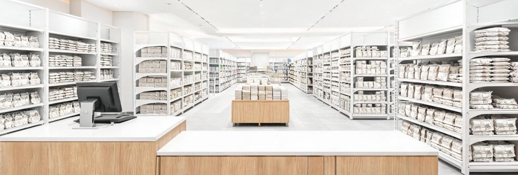 Retail store gondola shelving and wooden display table with checkout counter