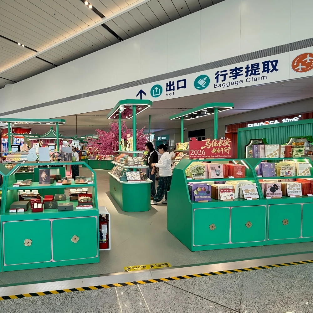Circular column merchandisers and ring-shaped ceiling lights in a retail store design installation, open-island layout with green fixtures