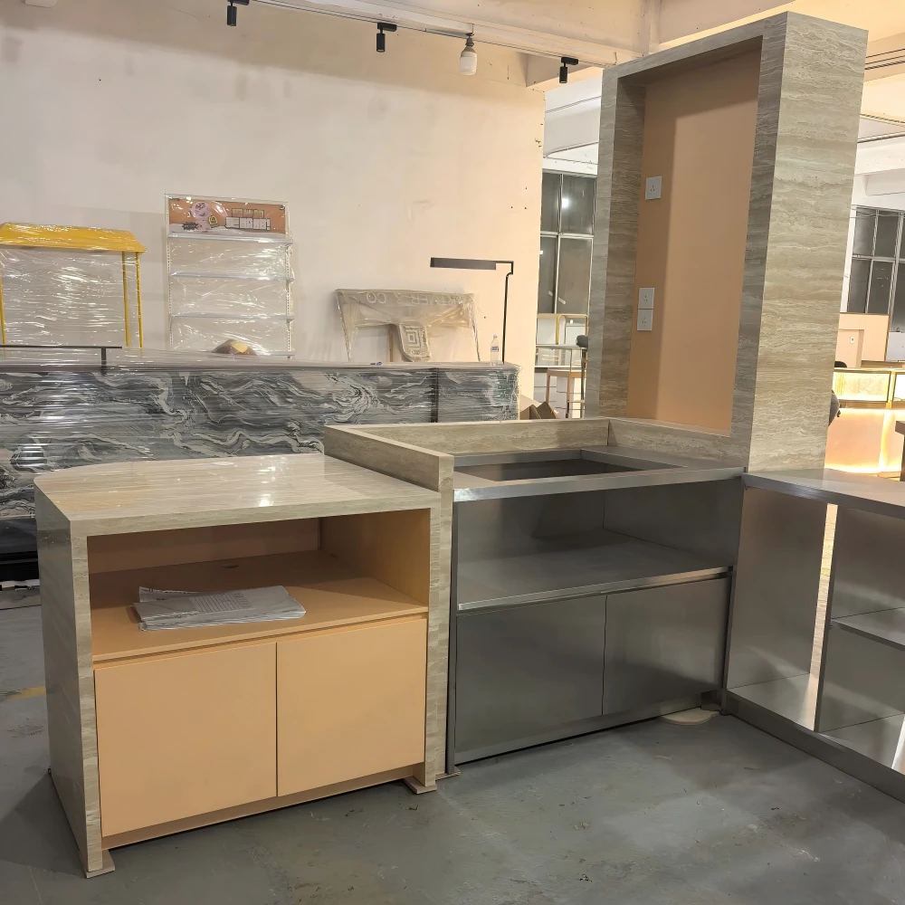 Cream stone-faced POS counter with vertical signage panel and joinery detail in a retail store fixtures production sample