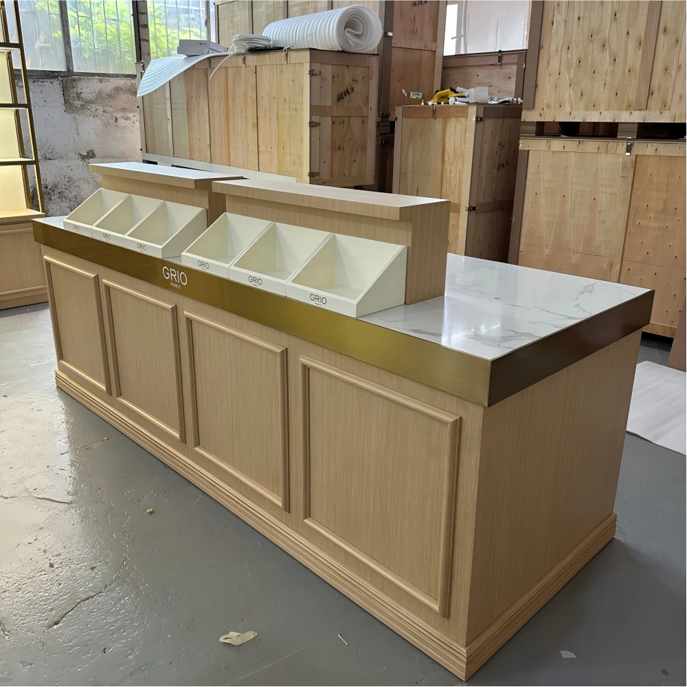 Paired light-oak display counters with marble-look surfaces and gold-trimmed sloped bins on the factory QC floor