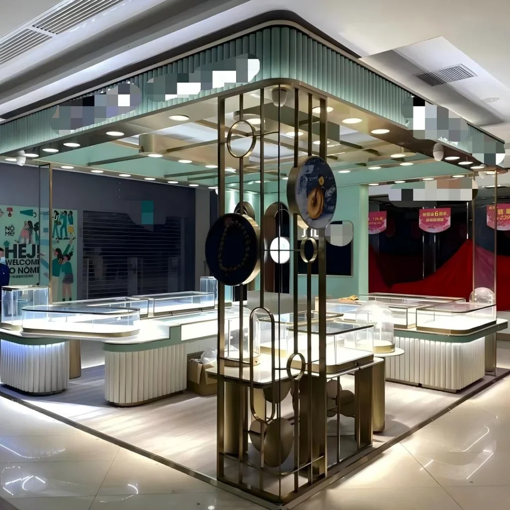 Jewelry kiosk in mall interior: curved white counters with fluted bases, glass dome displays, central column with suspended discs, arched mirror niche
