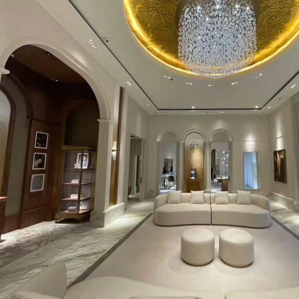 Walnut arch and crystal chandelier over a reception lounge in a classical jewelry salon