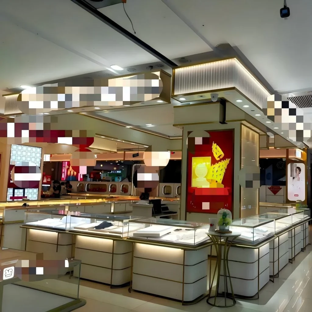 零售連鎖店中黃金珠寶展示櫃,採用奶油色條紋底座與香檳金飾邊,環繞發光品牌立柱