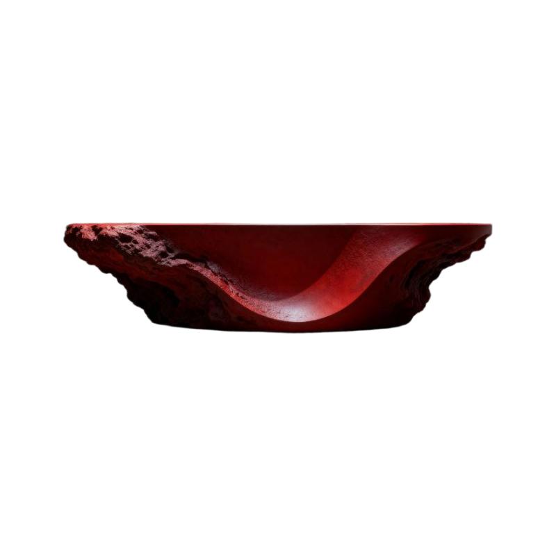 Meja resepsionis skulptural dengan dasar batu ukir dan finishing merah matte di latar belakang putih