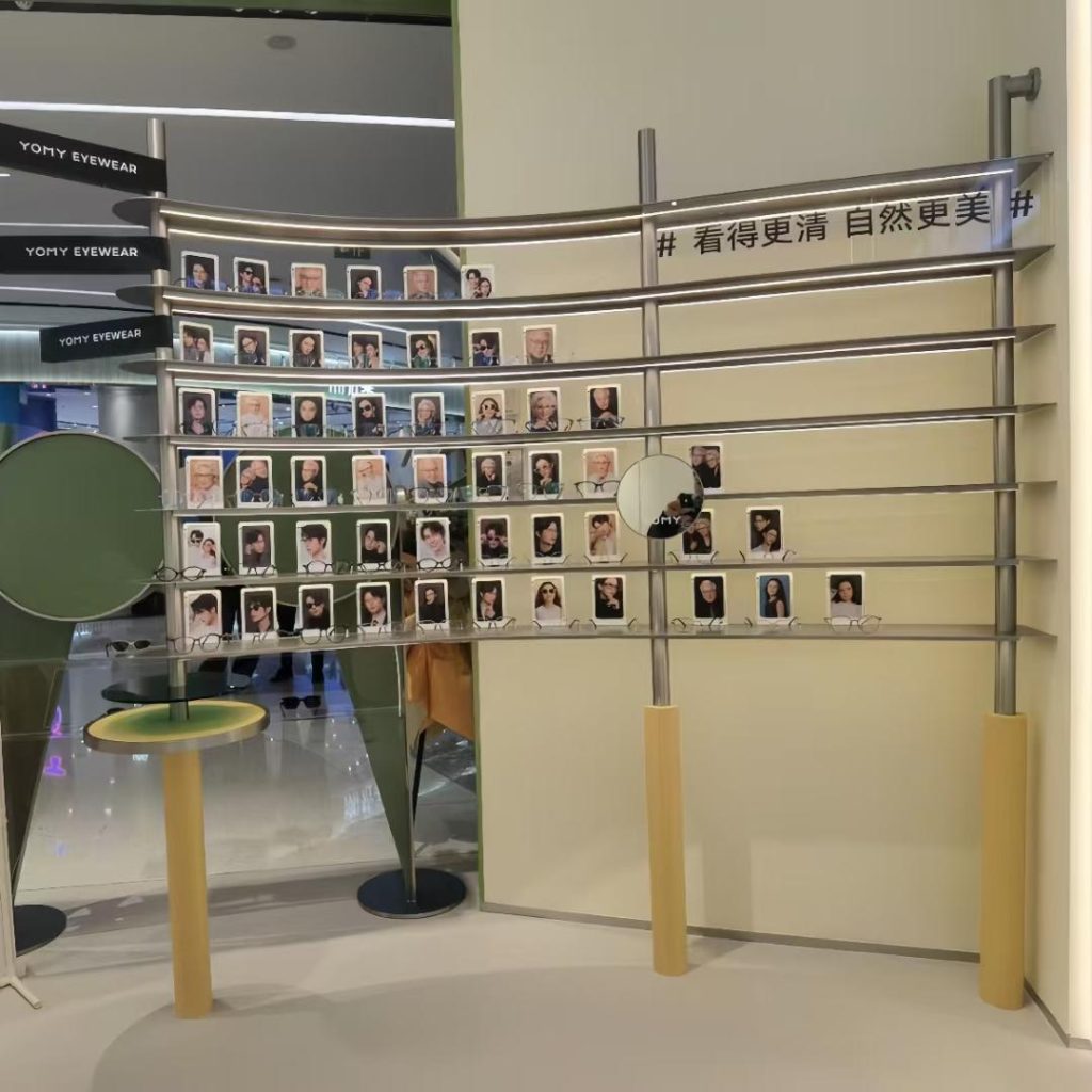 Curved sunglass display wall in gunmetal poles and lit shelves with portrait card arrays at a China eyewear store