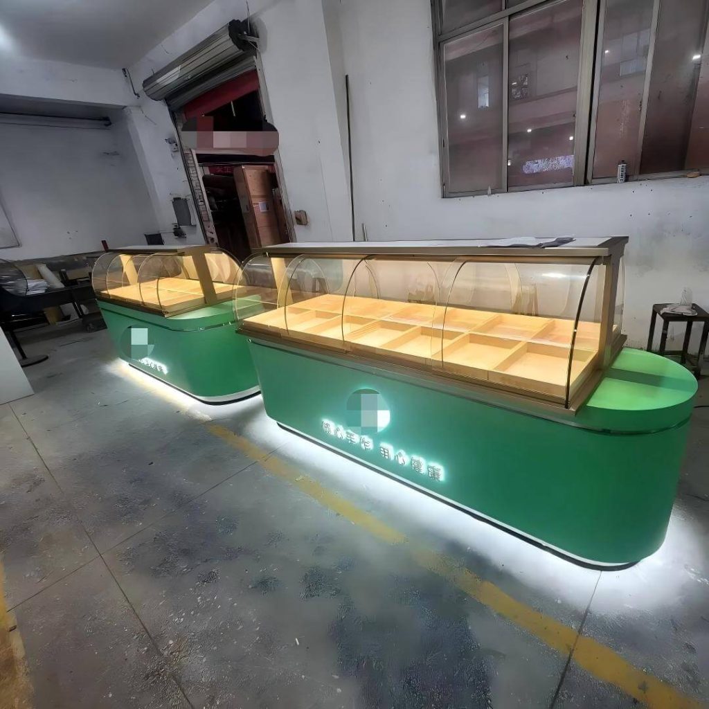 Paire de présentoirs à desserts avec dômes en verre courbé, compartiments en bois divisés et cadres or champagne sur socles lumineux