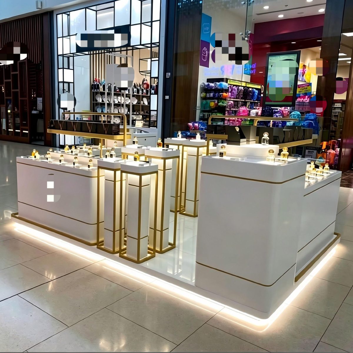 white and gold customized kiosk curved perfume concession in a mall with glowing plinth, gold-frame pedestals and multi-level counters