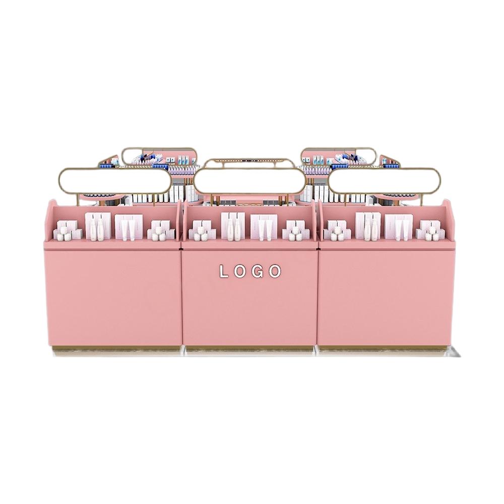 blush pink three-bay kiosk makeup unit on white background with glowing oval sign frames, open compartments and drawer storage